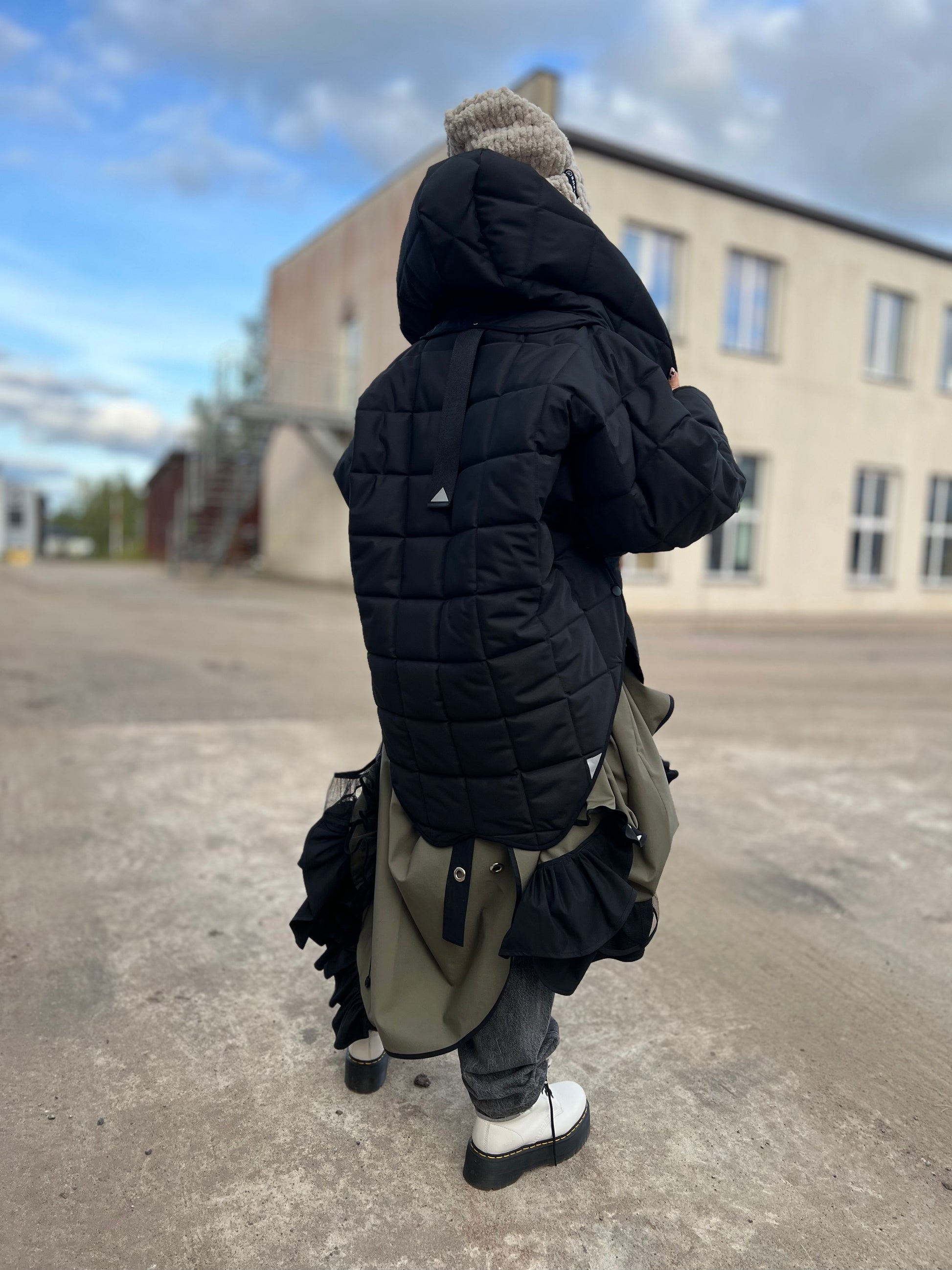 Blond model wearing short quilted hooded jacket in outdoor setting