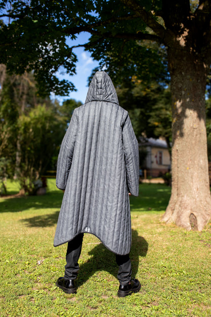Man wearing a grey unisex quilted coat, view from the back