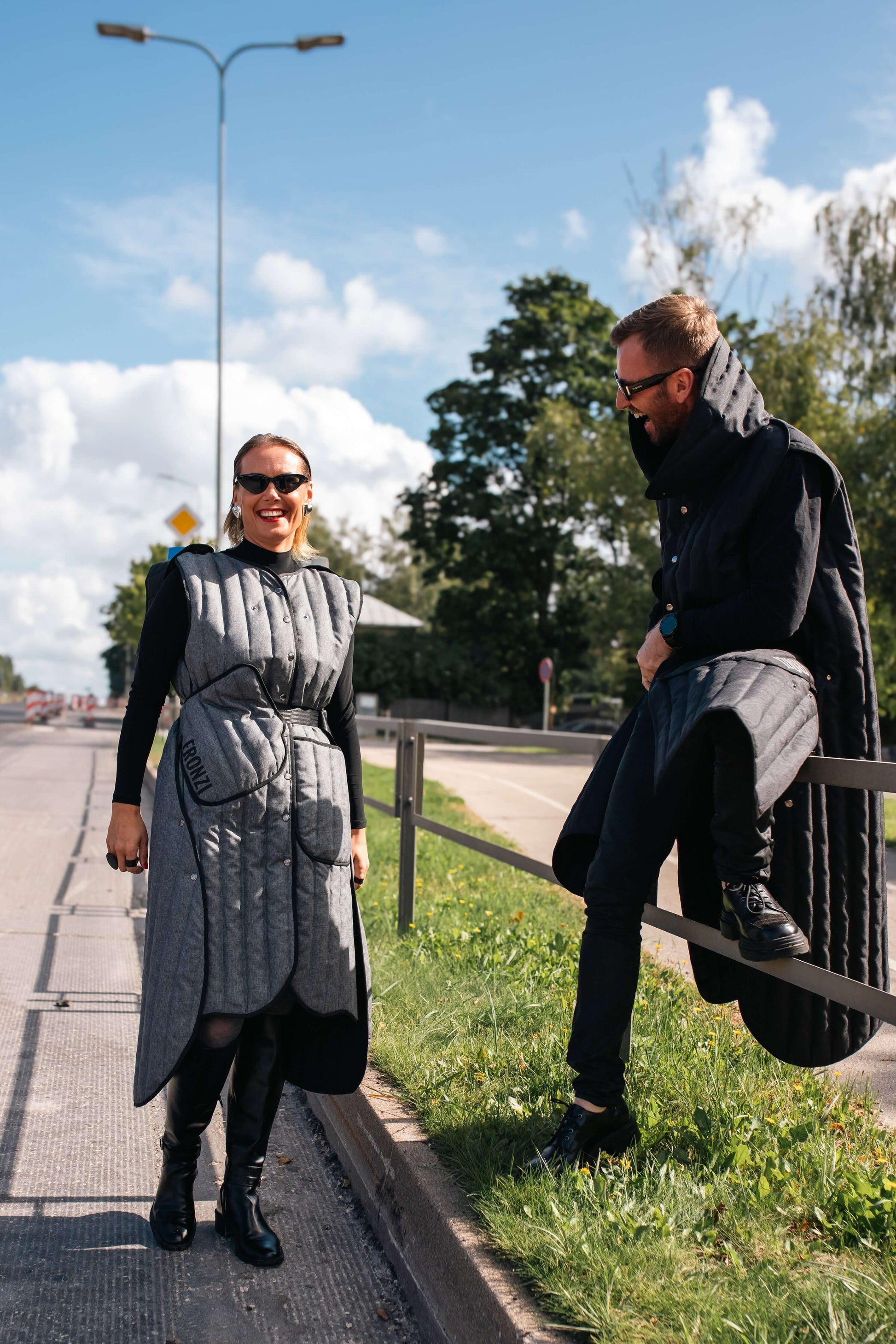 Man and woman laughing while wearing Fronzi long vests in grey and black