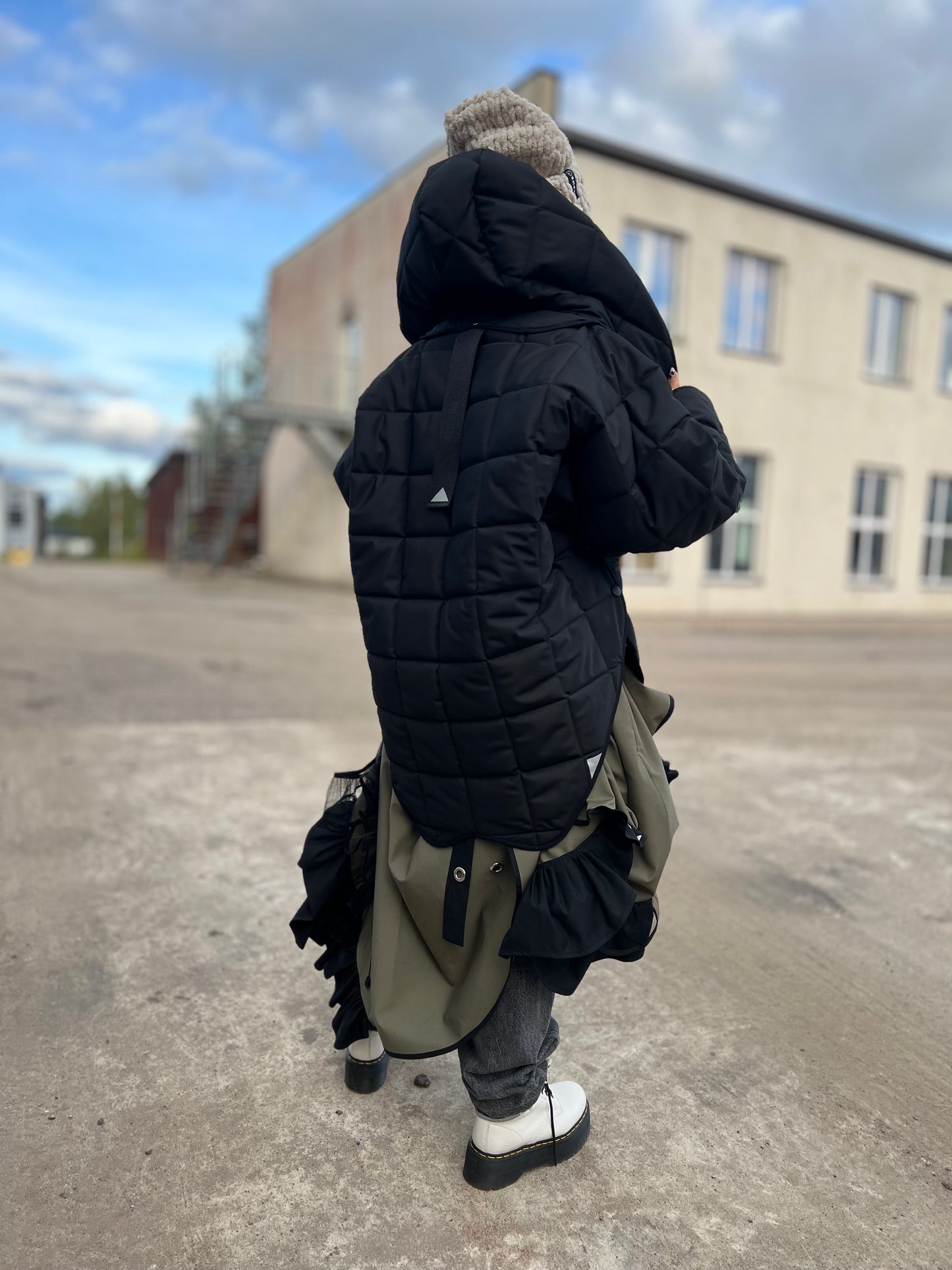 Blond model wearing short quilted hooded jacket in outdoor setting