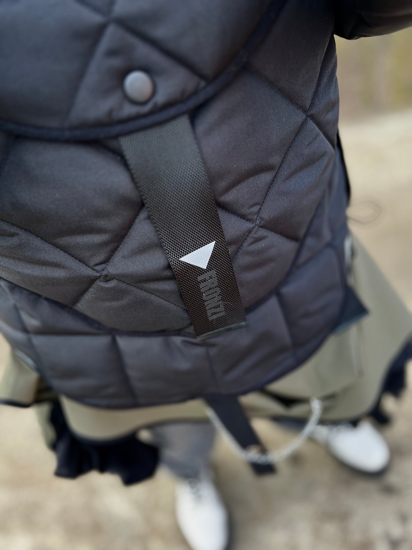 Blond model wearing short quilted hooded jacket in outdoor setting