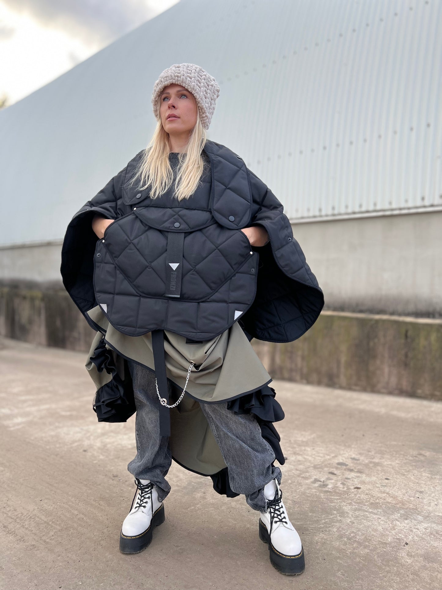 Blond model wearing short quilted hooded jacket in outdoor setting