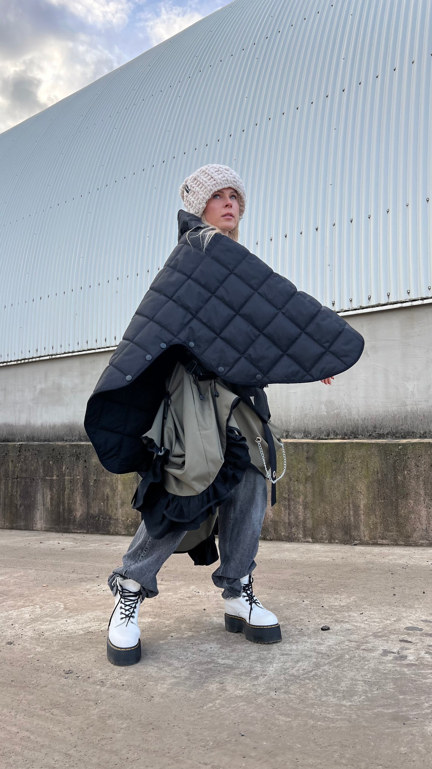 Blond model wearing short quilted hooded jacket in outdoor setting