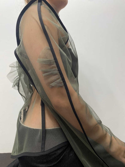 Close up to the right sleeve of a khaki green see-through top