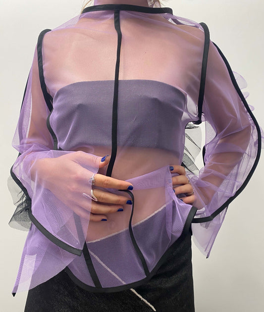 Model wearing a purple see-through top with black lines and frill details