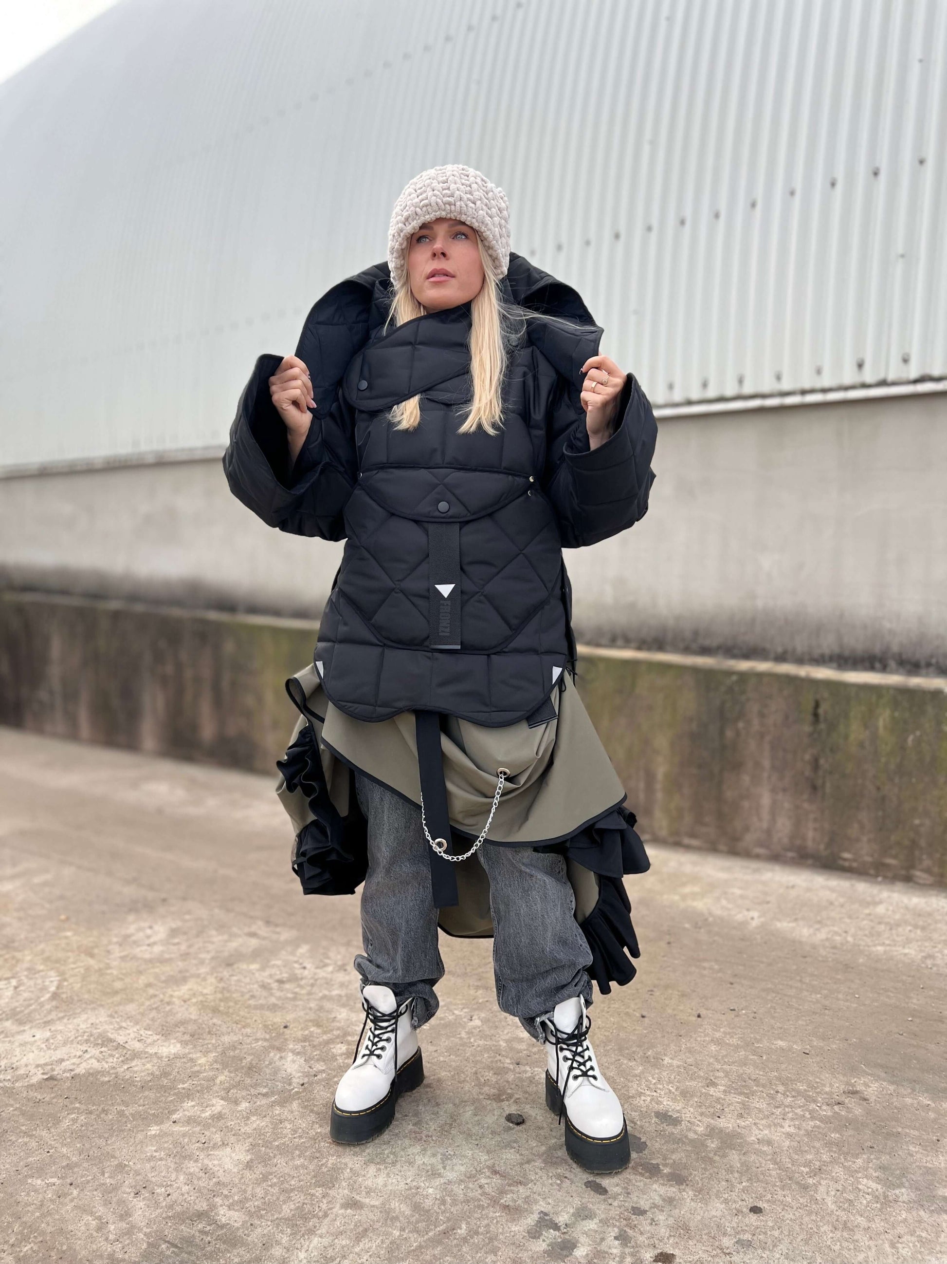 Blond model wearing short quilted hooded jacket, with hood on 