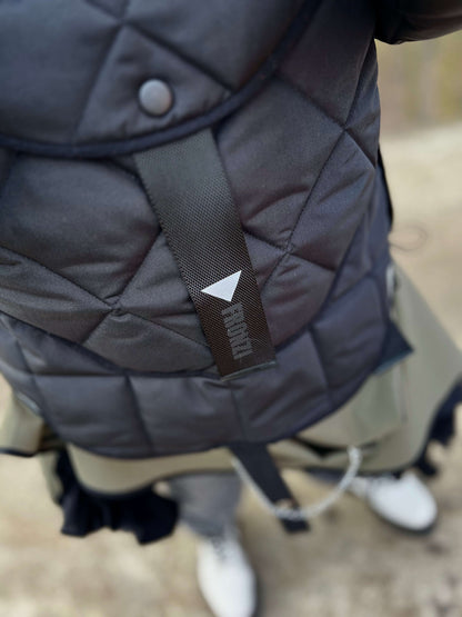 Close up of a reflective detail on the short quilted hooded jacket 