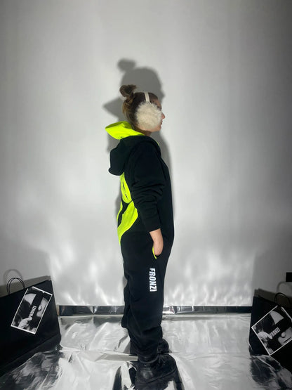 Model wearing a black Fronzi onesie with neon details and reflective parts, view from the side