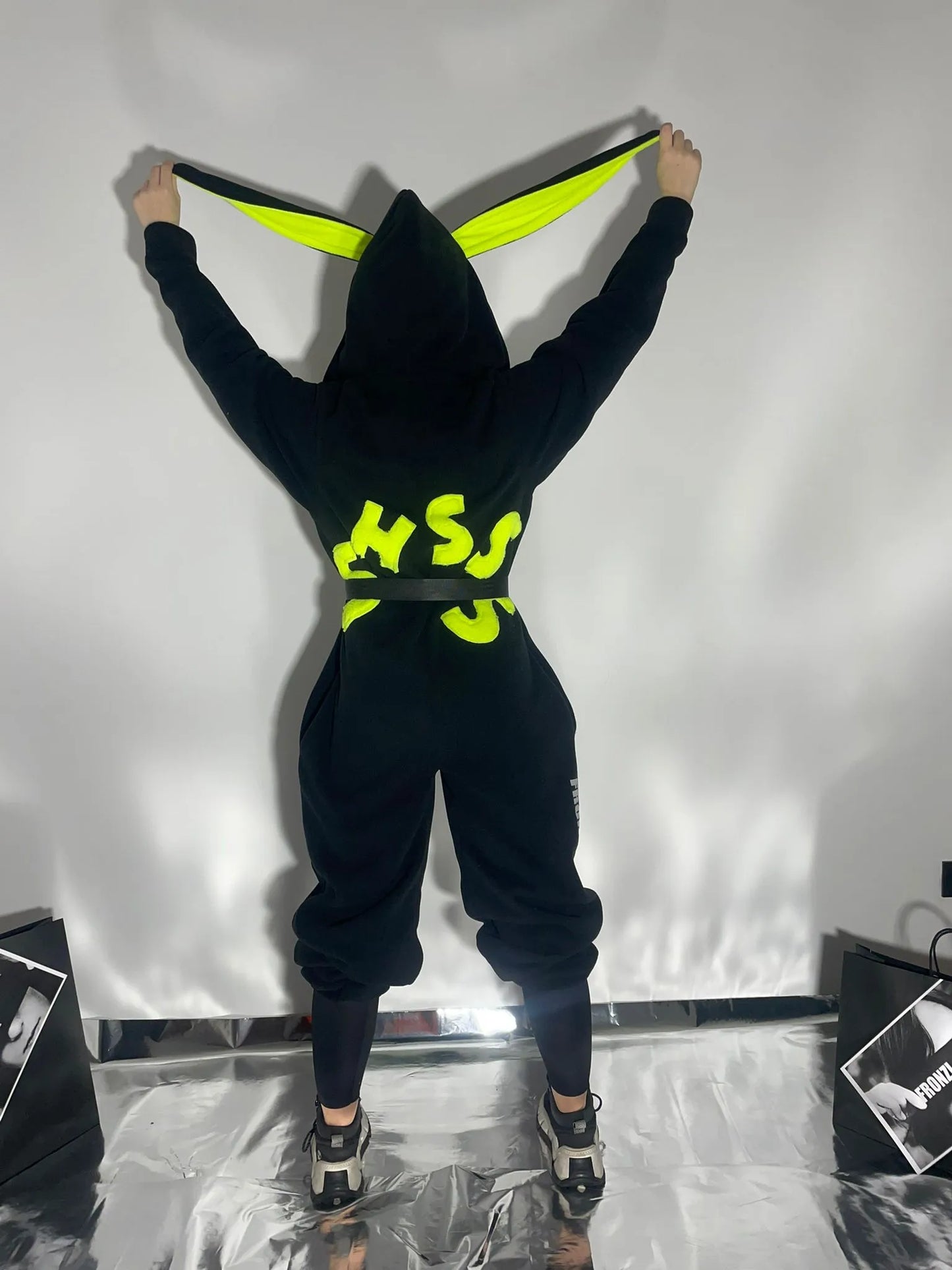Black fleece onesie shot from the back with neon details on the back and ears