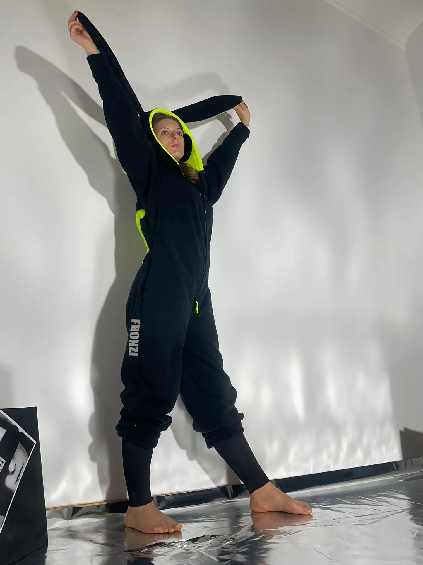 Model wearing a black fleece onesie shot from the side