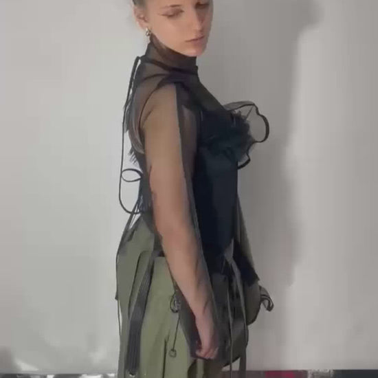A video of model wearing a khaki color skirt that can transform into a dress, close ups and model walks away