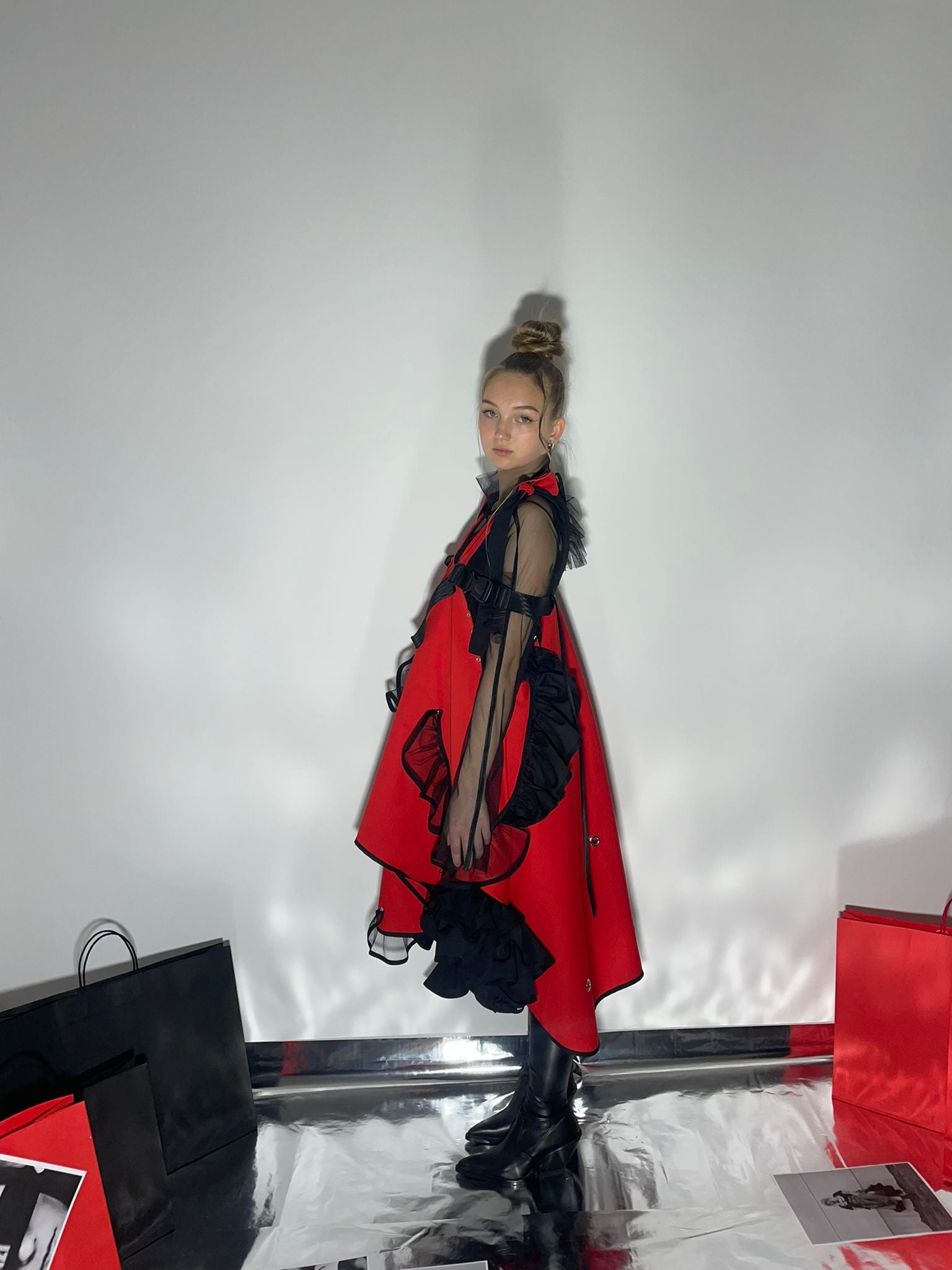Side view of model wearing a red ress with black details