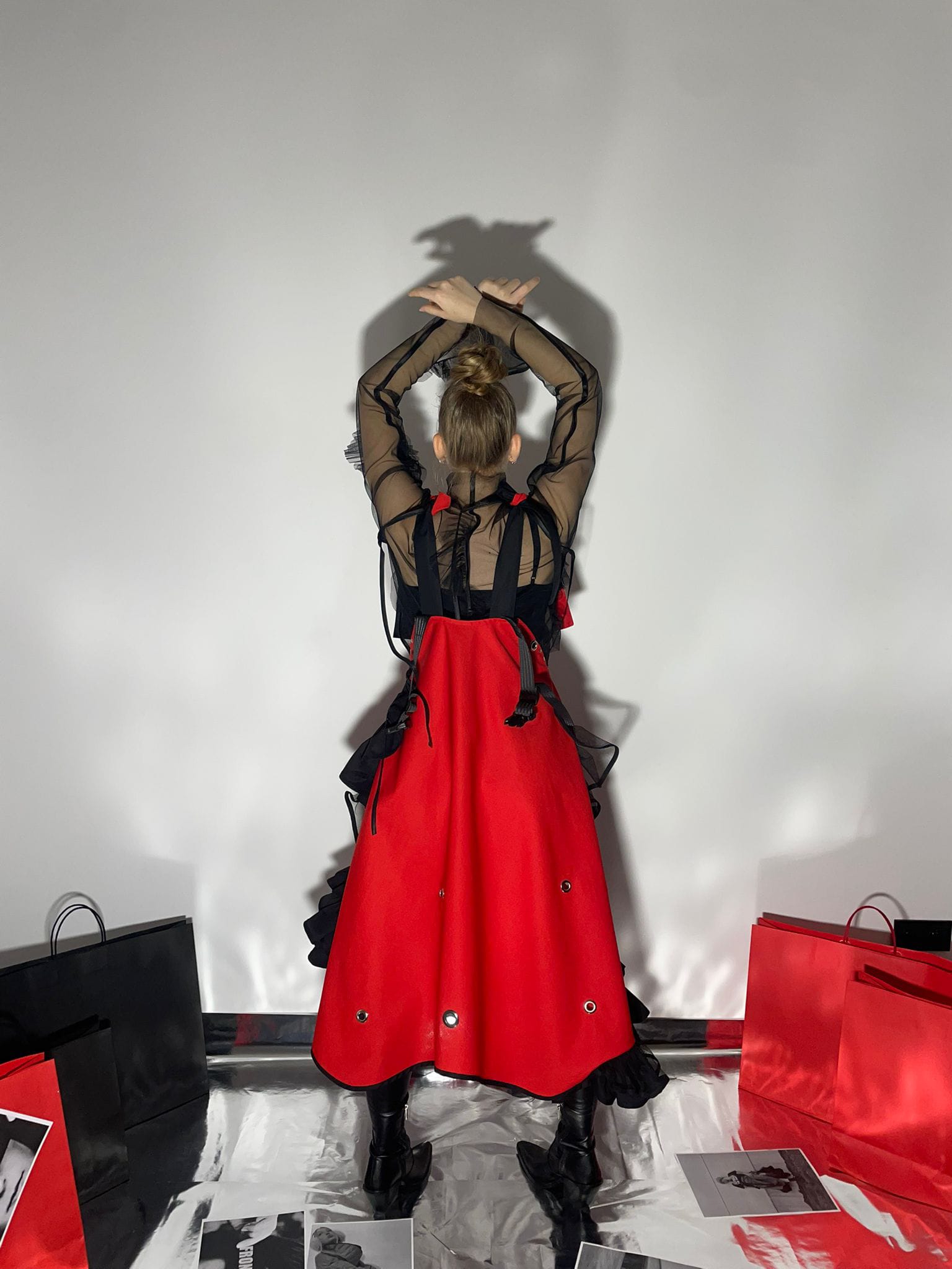 Model wearing a Fronzi red dress from the back with her hands up